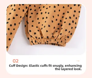 Close-up of elastic ribbed cuff design on ochre cotton sweatshirt with black polka dots
