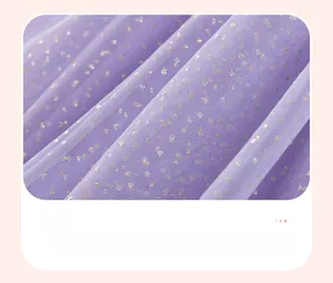 Détail du tissu en tulle violet avec des paillettes dorées pour robe de fille