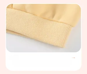 Détail de l'ourlet en maille côtelée douce sur le sweat jaune d'automne pour tout-petits