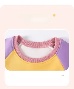 Detail eines Kinderpullovers mit kontrastierendem lila-gelbem geripptem Halsausschnitt