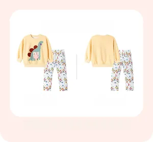 Détail du sweat-shirt jaune pour enfant avec écusson dinosaure et pantalon imprimé