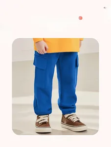 Detail view of boys blue cargo pants featuring large side pockets and elastic ribbed cuffs