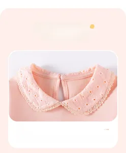 Detail of pink cotton girl's top featuring a white lace Peter Pan collar with embroidery