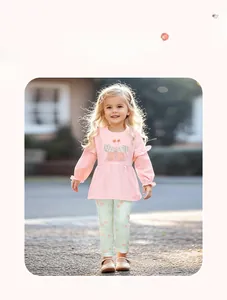 Détail du haut rose à manches longues avec broderie papillon et legging à fleurs