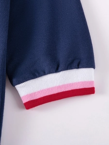 Dettaglio vestito in maglia blu scuro da bambina con polsini a righe bianco rosa rosso