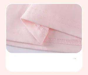 Gros plan de la double couture sur l'ourlet d'un haut en coton rose pour fille