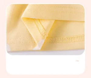 Close-up of yellow cotton girl dress hem showing delicate double-needle flat stitching