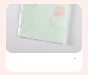 Détail du pantalon en maille verte pour bébé fille avec imprimé floral et ourlet renforcé