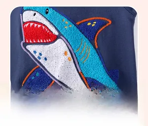 Detail of blue cotton boy hoodie showing 3D shark towel embroidery texture and stitching