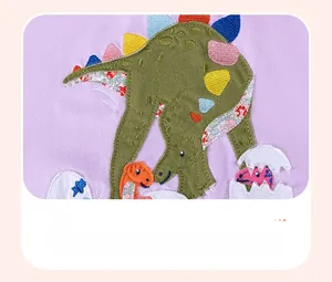 Detail of colorful dinosaur appliqué and embroidery on purple cotton girls dress