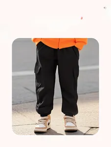 Detail of black cargo jogger pants for boys featuring flap pockets and elastic cuffs