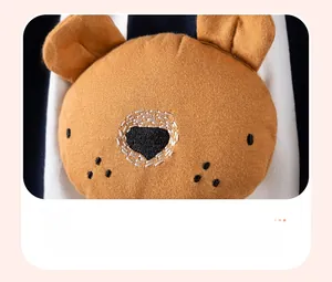 Dettaglio del ricamo dell'orso 3D su tessuto a righe blu navy del vestito per bimbi