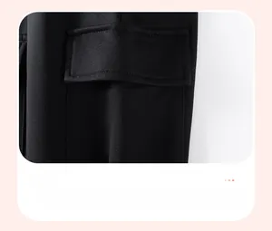 Detail of cargo pocket with flap on black boys' trousers, featuring neat stitching