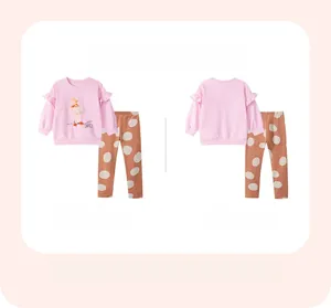 Flat lay of pink girls ruffles sweatshirt with dance print and brown polka dot pants