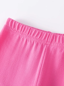 Close-up of bright pink elastic waistband on cotton autumn cartoon pants for children