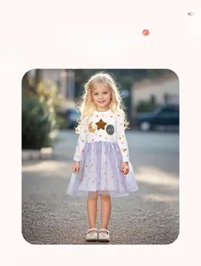 Detailed view of girls' long sleeve dress featuring moon patches and purple tulle skirt