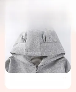 Détail du sweat gris à capuche avec fermeture éclair et oreilles d'animaux 3D