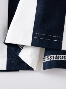 Dettaglio dell'orlo di un vestito in cotone a righe blu e bianche con cuciture precise