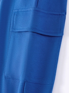 Close-up of royal blue cargo pocket detail with stitching on autumn boys' trousers