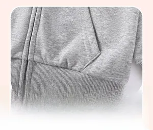 Détail du sweat à capuche gris clair avec ourlet côtelé et poche latérale pratique