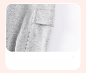 Close-up of grey knit trousers featuring a functional patch pocket with a rectangular flap