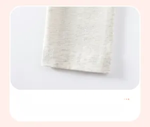Dettaglio dell'orlo dei pantaloni in maglia grigia con cuciture a doppio ago di precisione
