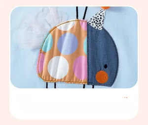 Detailed close-up of cartoon appliqué embroidery with mesh on blue knit fabric