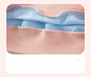 Close-up of pink ribbed knit fabric with light blue fleece lining and reinforced stitching