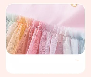Dettaglio di tulle a rete multicolore su un abito di cotone rosa per bambine