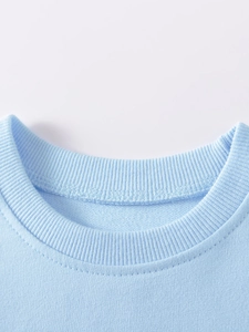 Girl's light blue knit sweatshirt with elastic ribbed crew neck and double stitching
