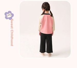 Rear view of girl's pink and beige raglan sleeve top with black wide-leg trousers outfit