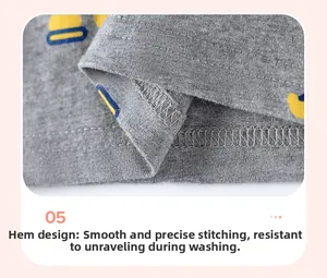 Détail de la couture double à l'ourlet sur t-shirt gris en coton avec motif canard