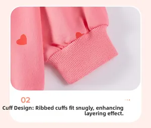 Detail of pink knitted sweatshirt ribbed cuff featuring red heart print patterns