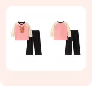 Flat lay of girl's pink sweatshirt with bear patch and black pants showing front and back