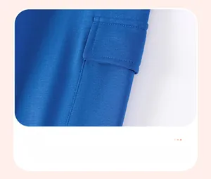 Detailansicht der aufgesetzten Seitentasche am blauen langärmeligen Baumwollshirt für Jungen