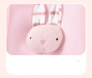 Détail d'un lapin en peluche 3D avec oreilles rayées et broderie sur un sweat rose
