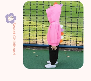 Detail of pink hoodie with dinosaur spine accents and black cargo pants for kids