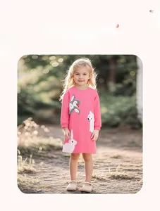 Pink long-sleeved girls dress with animal applique embroidery in a natural outdoor setting