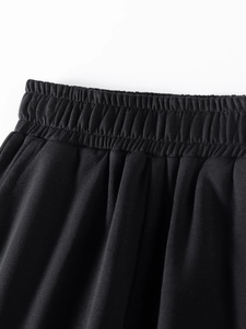 Detail of elastic waistband on black cotton sweatpants for boys featuring knit fabric texture