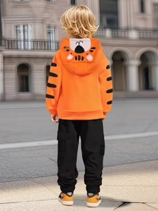 Tiger themed orange hoodie with 3D ears and black joggers for boys on street background