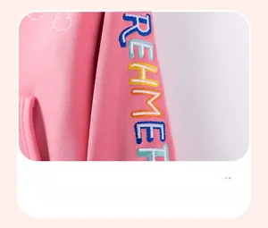 Detail of pink fleece hoodie sleeve with colorful embroidered REHME letter design