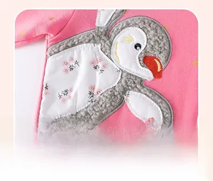 Detail of pink cotton dress with penguin applique, floral fabric and gold stars