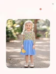 Détail de la robe en coton à fleurs avec broderie canard jaune et jupe bleu ciel