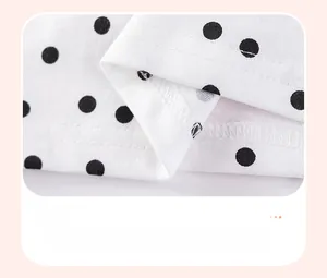 Detail view showing the reinforced double-stitch hem on white polka dot cotton fabric
