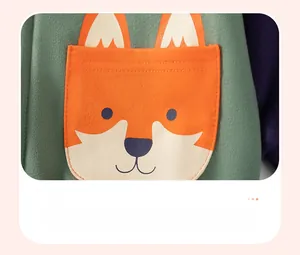 Close-up of green knit hoodie featuring a cute orange fox patch pocket and stitching
