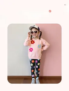 Toddler girl two-piece outfit featuring pink floral sweatshirt and patterned black leggings