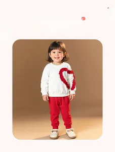 Detail view of toddler girl outfit with red ruffled heart patch and matching pants