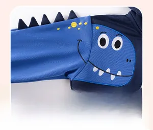 Détail de broderie de dinosaure et aileron 3D sur un sweat-shirt à capuche bleu