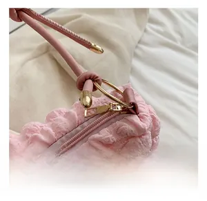 Detail of pink bubble texture bag with golden metal ring handle and smooth zipper hardware