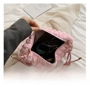 Pink bubble textured handbag interior capacity showing sunglasses and small cosmetics